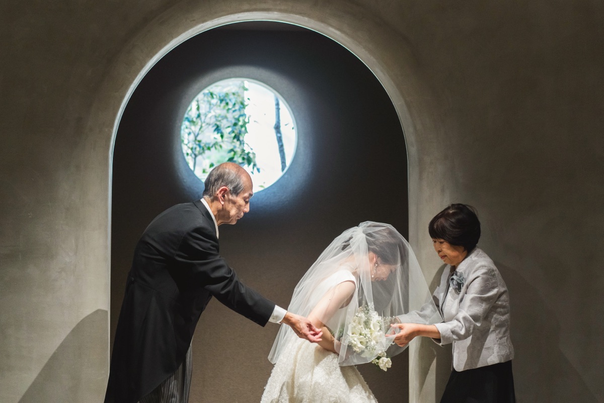 結婚式当日、花嫁のベールを整える家族の様子