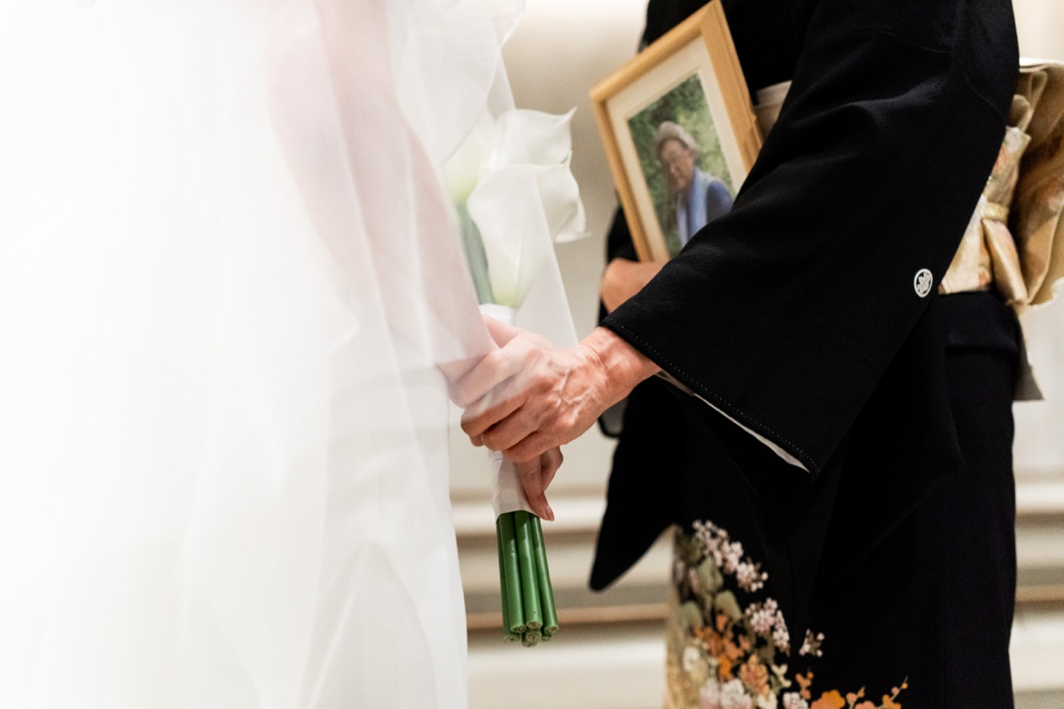 結婚式当日、花束と写真立てを手にする様子