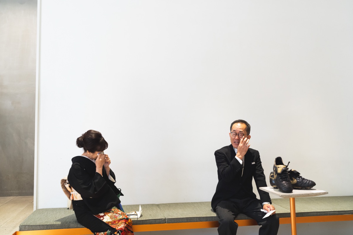 結婚式当日、思い出の品とともに涙を拭う参列者の様子